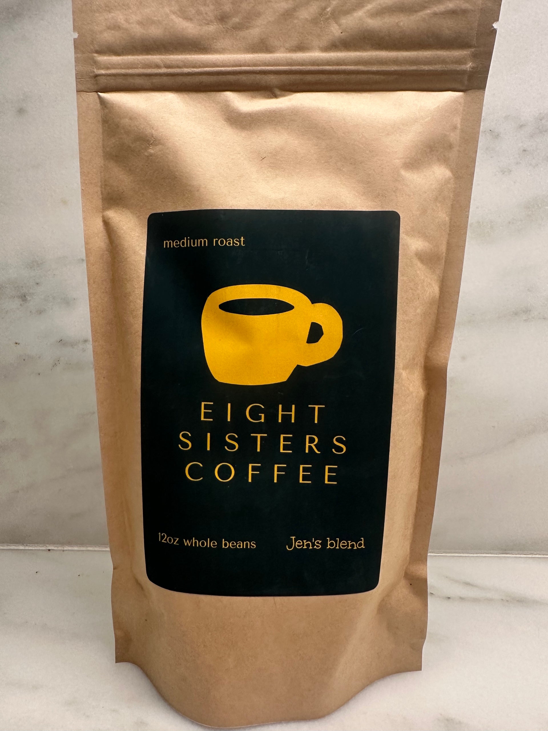 Eight Sisters Coffee's 12oz Jen's Blend - Medium Roast Whole Beans Coffee package on a marble surface