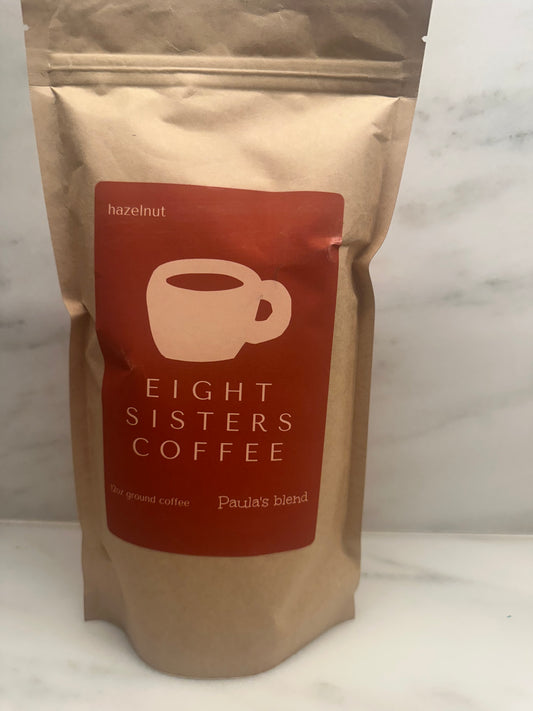 Eight Sisters Coffee 12oz Paula's Blend - Hazelnut ground coffee beans on a marble surface