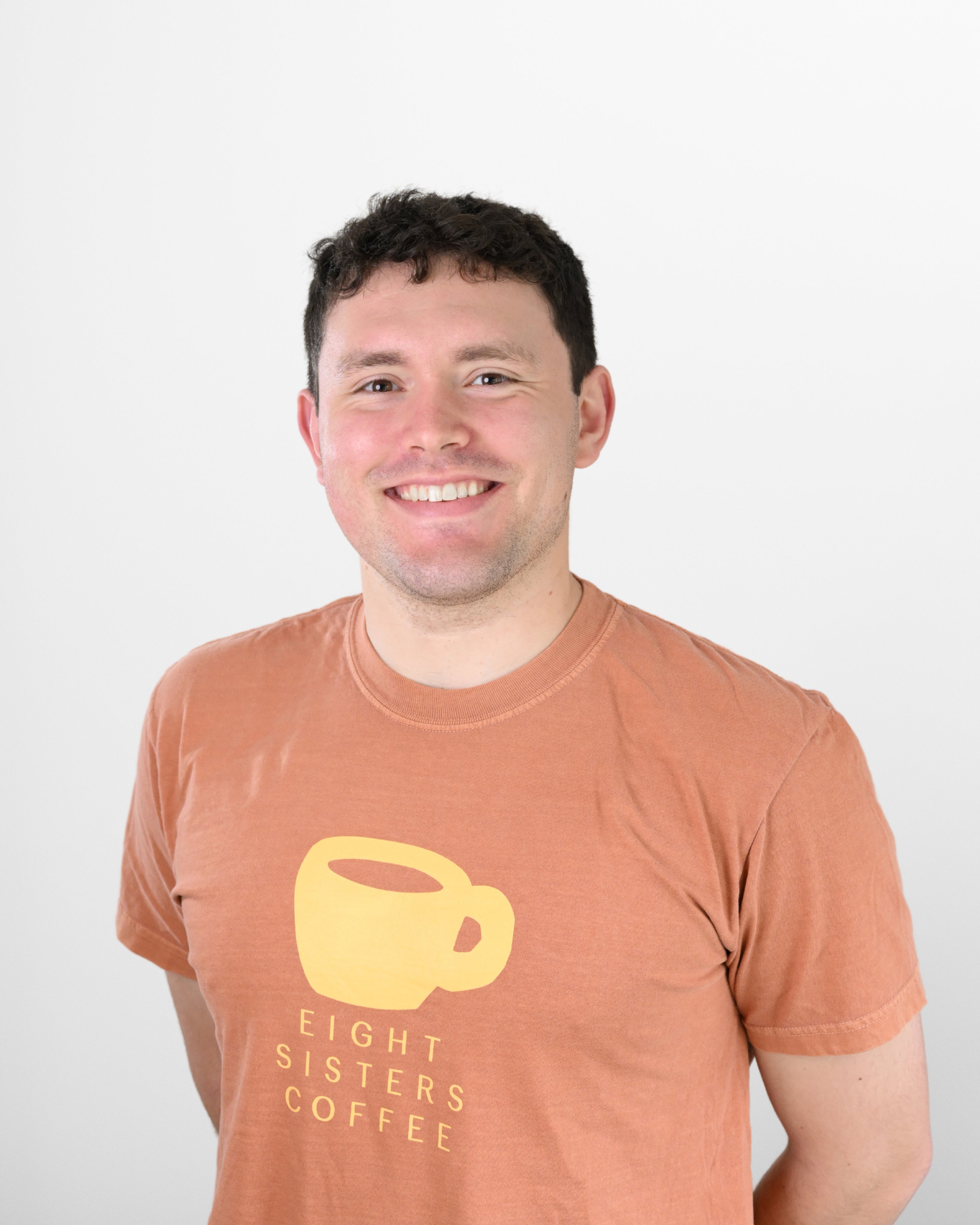 Hudson Sewall wearing an 'Eight Sisters Coffee' t-shirt against a white background