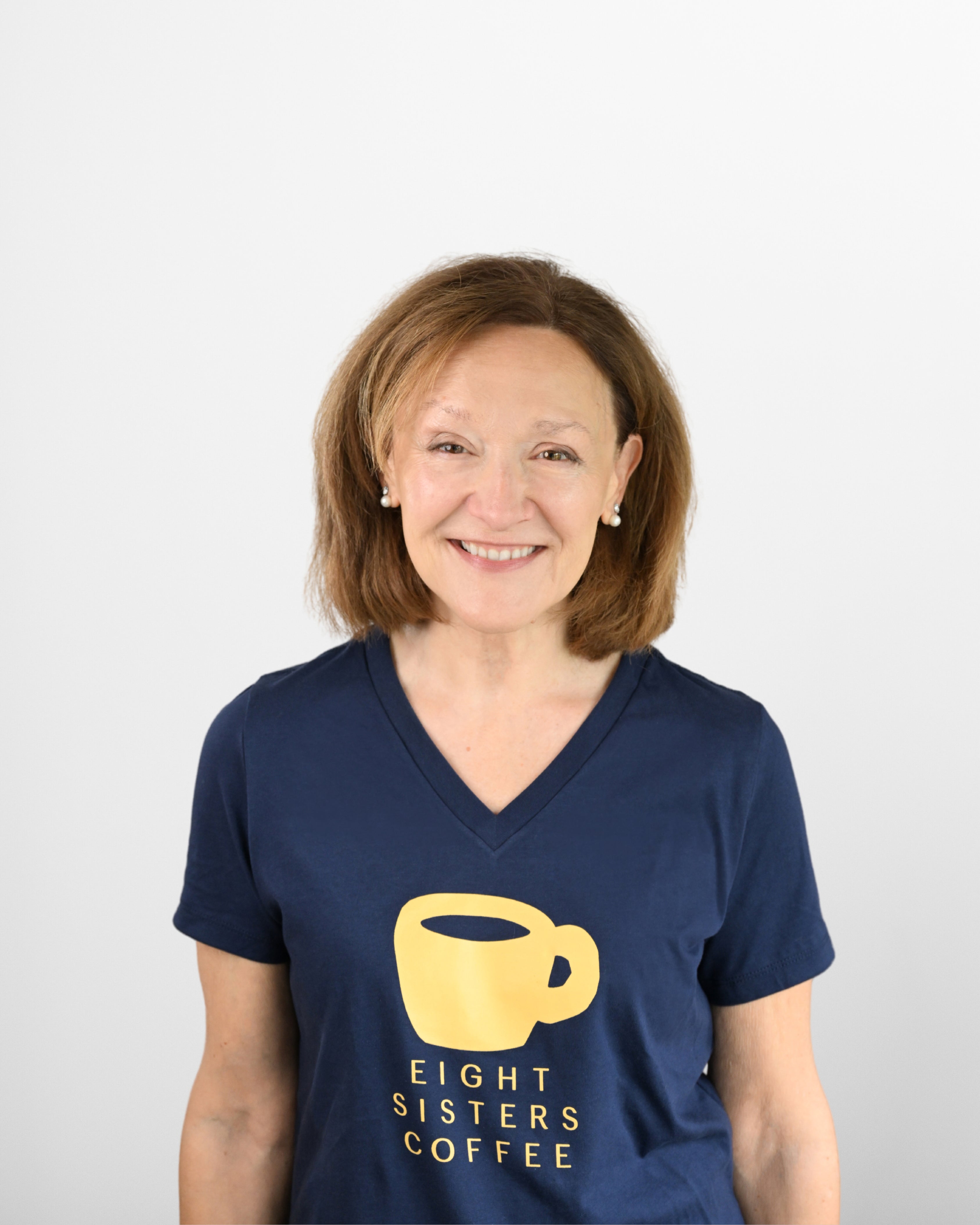 Lisa Sewall wearing a navy blue t-shirt with 'Eight Sisters Coffee' logo on a white background